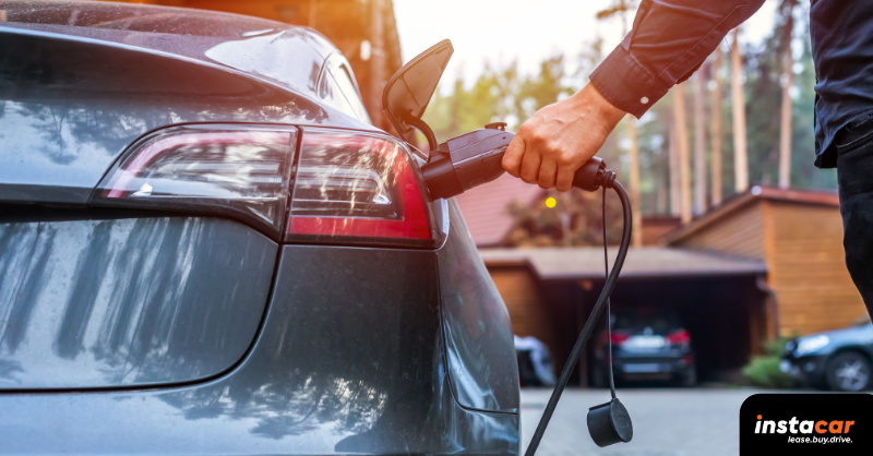 a man charging a plug-in hybrid car