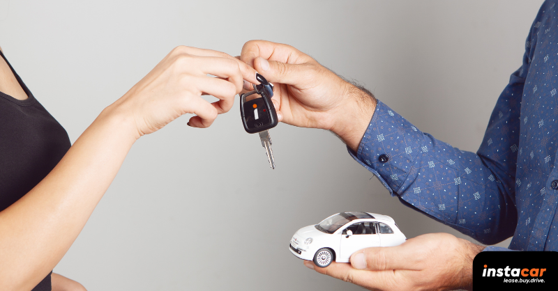 a female figure gving a toy Fiat 500 and a car key to a man