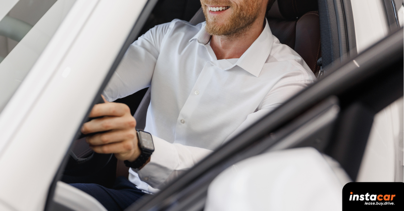 a man with a white shirt driving a car